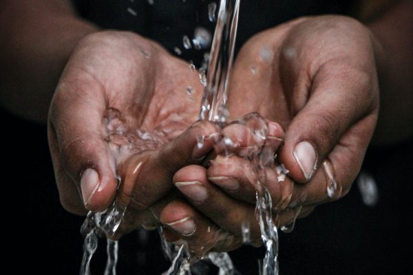 Gefiltertes Wasser läuft durch Hände
